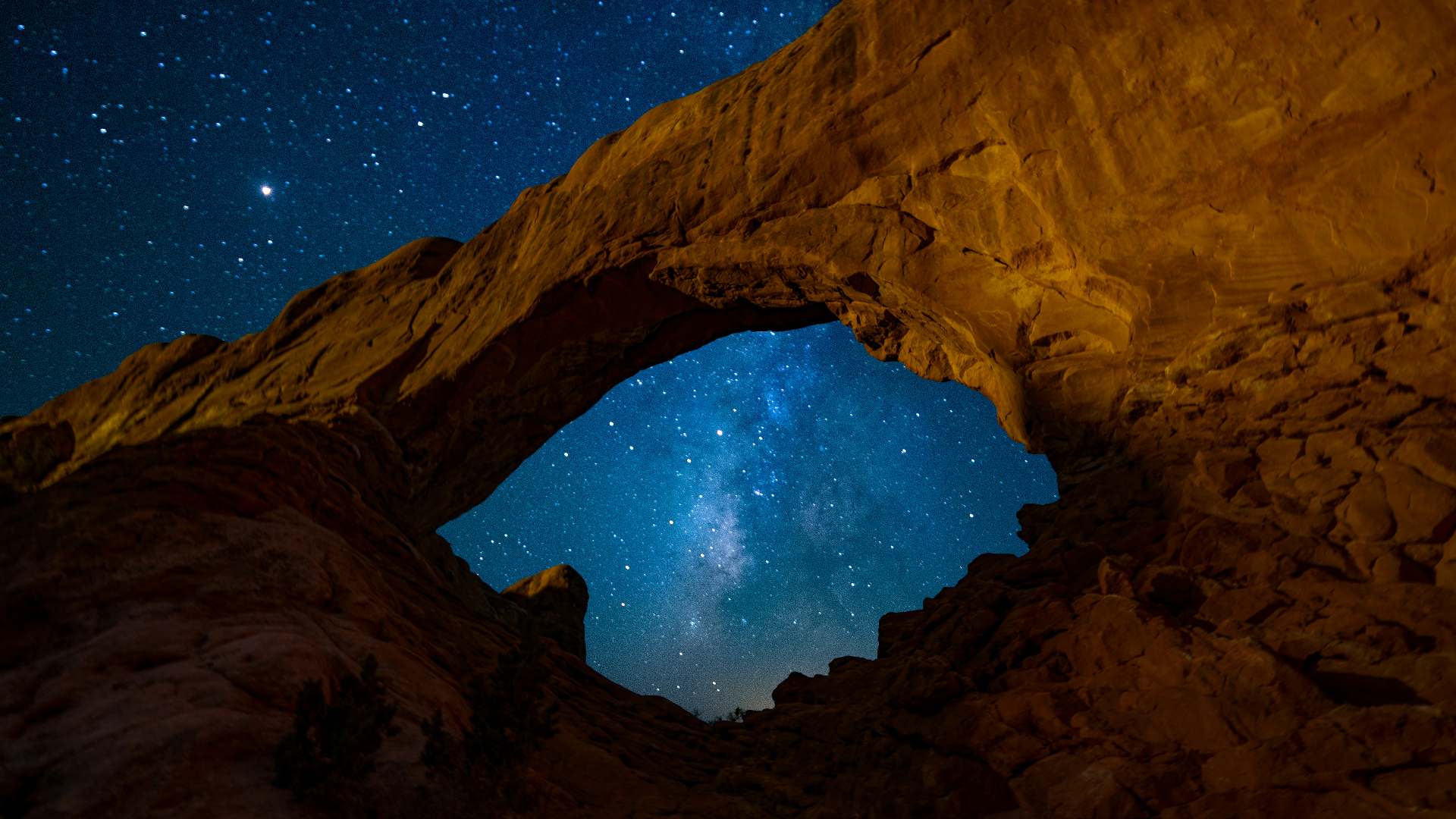 Starry night sky framed by a Utah sandstone arch